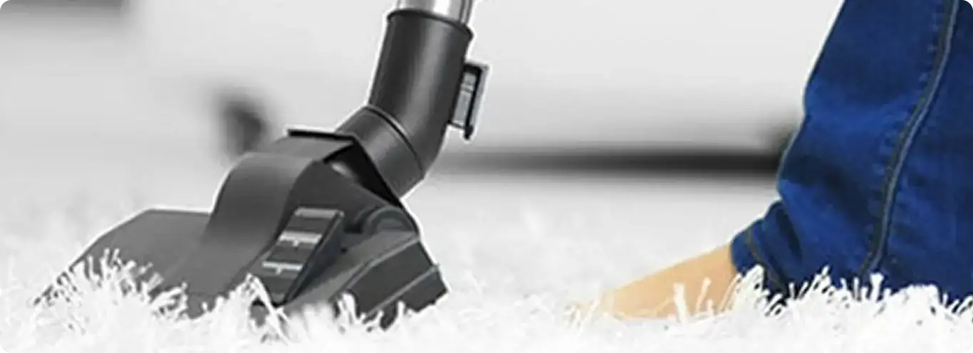 Close-up of a professional vacuuming a white carpet in Mc Farland.